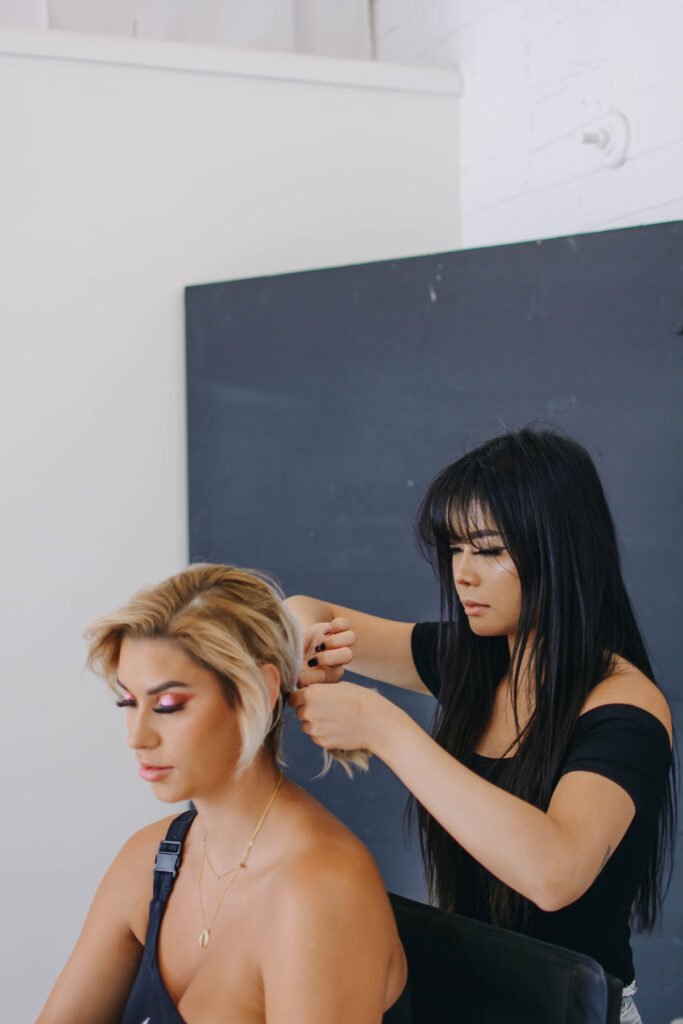 Scottsdale makeup artist and hairstylist, Lidia Win, working on Jordan Chelseamee's hair.