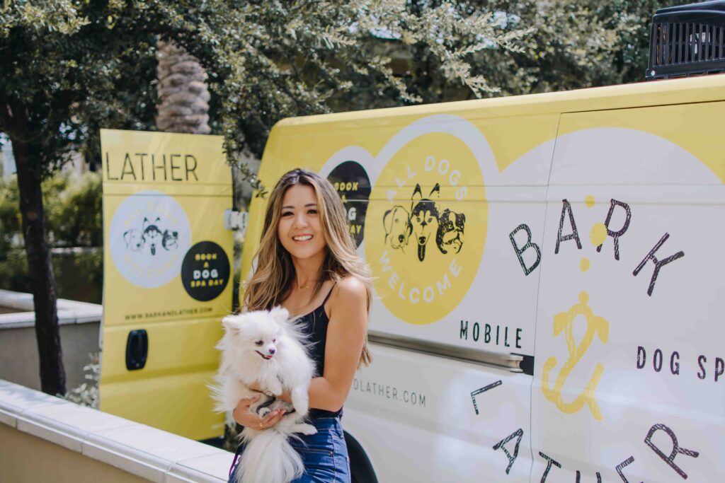Arizona blogger, Demi Bang, sitting in front of Bark & Lather, a traveling dog spa.