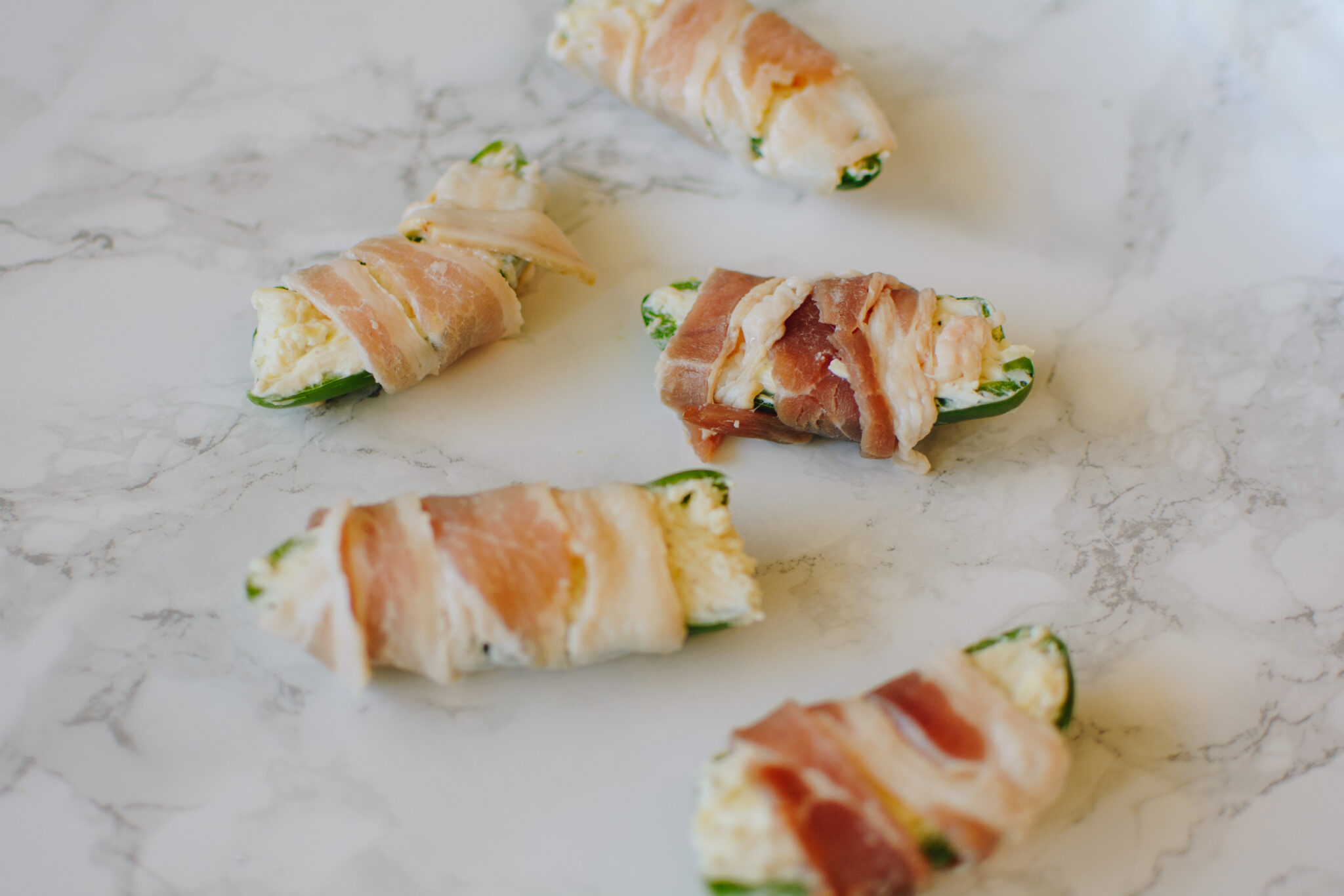 Arizona blogger Demi Bang shares how she wraps jalapeño poppers in bacon before cooking.