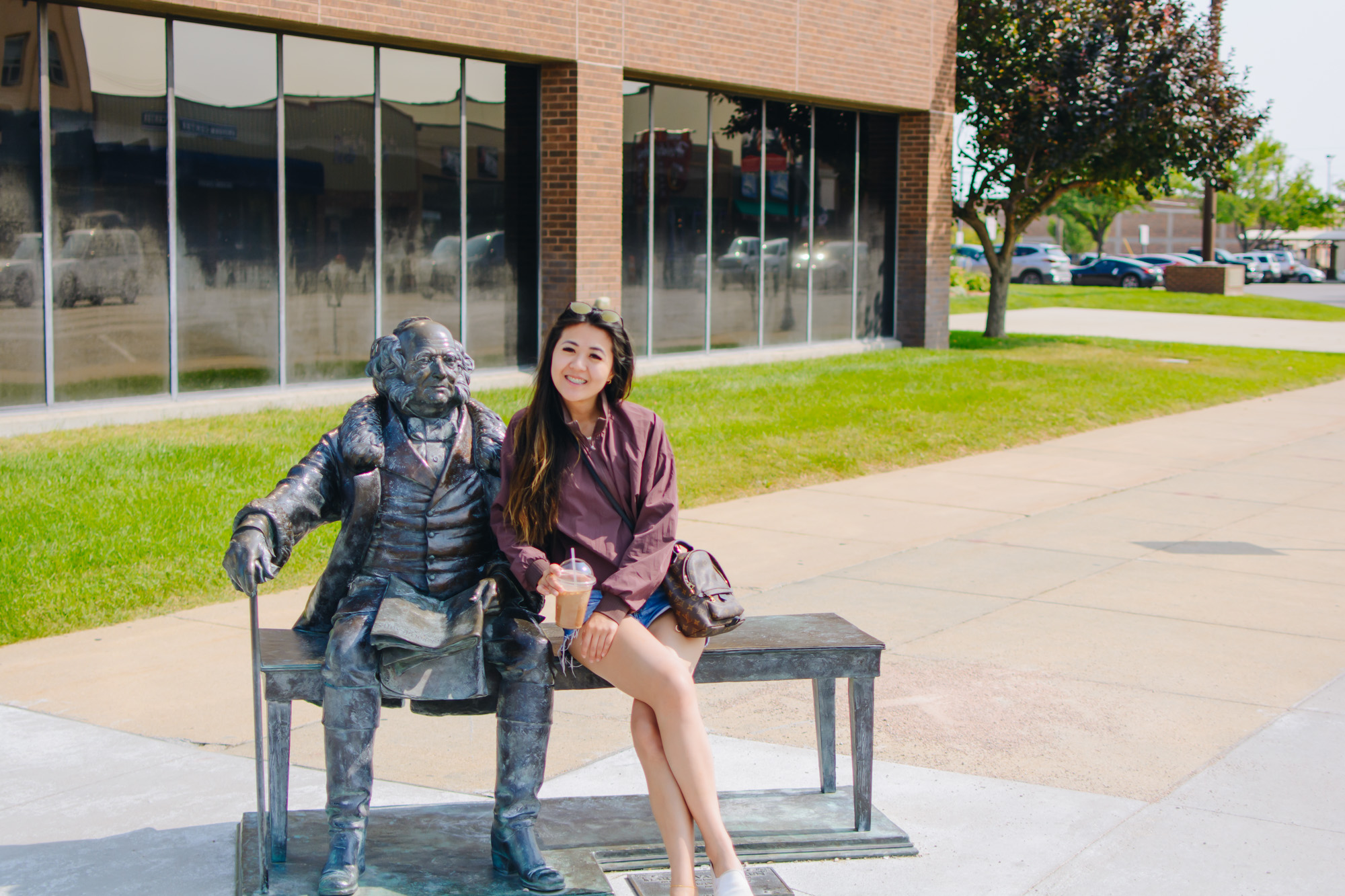 Lifestyle blogger Demi Bang sitting next to Martin Van Buren bronze statue in Rapid City, South Dakota.
