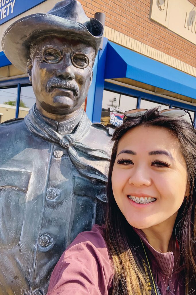 Lifestyle blogger Demi Bang standing next to George W. H. Bush bronze statue in Rapid City, South Dakota.