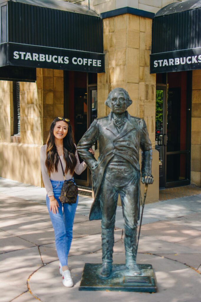 Lifestyle blogger Demi Bang standing next to George Washington bronze statue in Rapid City, South Dakota.