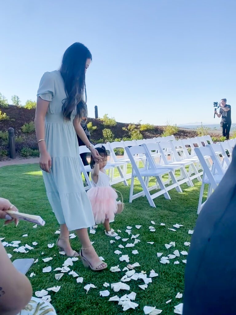 Arizona blogger Demi Bang walking down the aisle with the flower girl at a wedding in Salt Lake City, Utah.