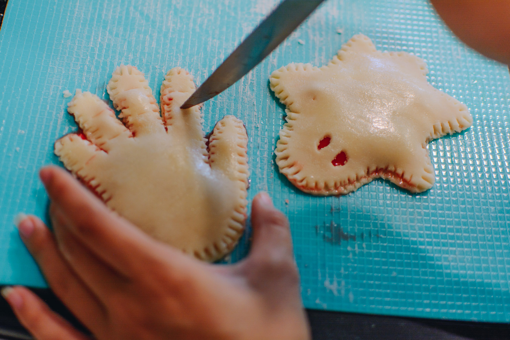 Arizona blogger Demi Bang creating slits in her spooky hand pastries. 