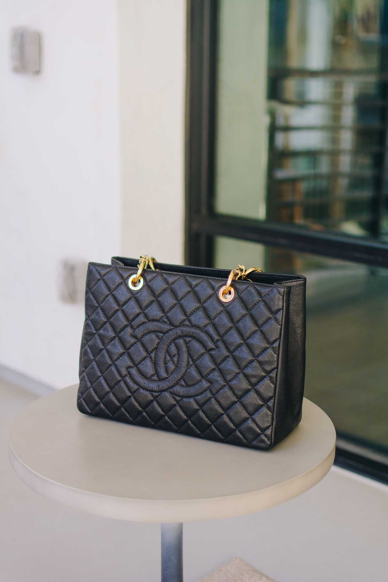 The front view of a Chanel GST in black caviar leather.